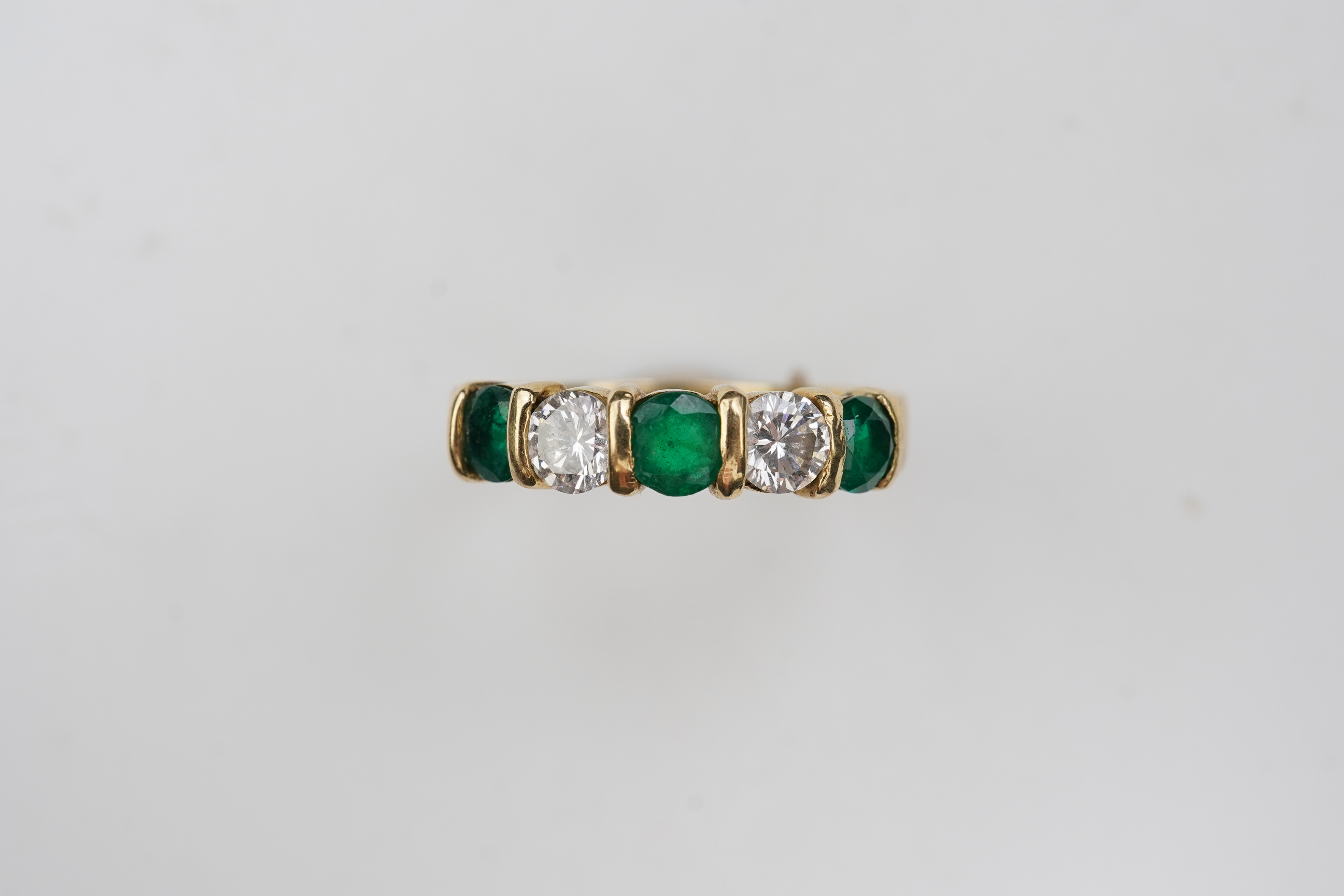 An emerald and diamond five-stone ring
